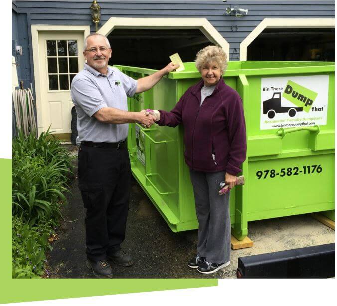 A man and woman standing next to a green dumpster, shaking hands for a junk removal franchise agreement.